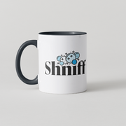 A white ceramic coffee mug with a black handle and black interior, featuring a graphic of three blue cartoon mice and the word 'Shniff' in black text on the front.